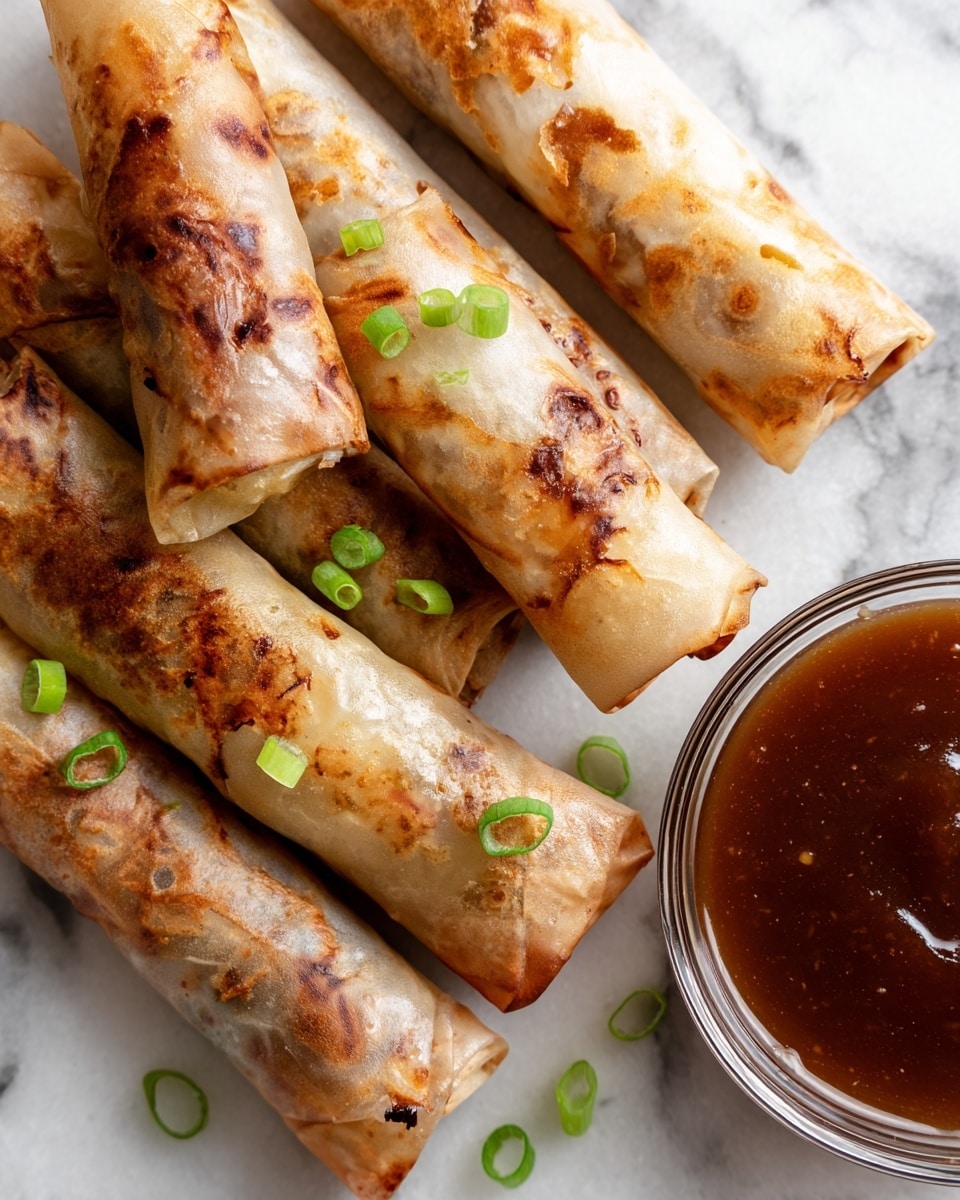 This image shows four pieces of golden-brown fried rolls inside a black air fryer basket with holes. Each roll has a slightly crispy and shiny texture, with uneven coloring showing some lighter and darker brown spots from cooking. The rolls are arranged close to each other, three lying horizontally at the bottom and one held diagonally above by a blue silicone tong held by a woman's hand. The inside of the fryer's basket is dark black with round holes, and the whole scene is set on a white marbled surface. photo taken with an iphone --ar 4:5 --v 7