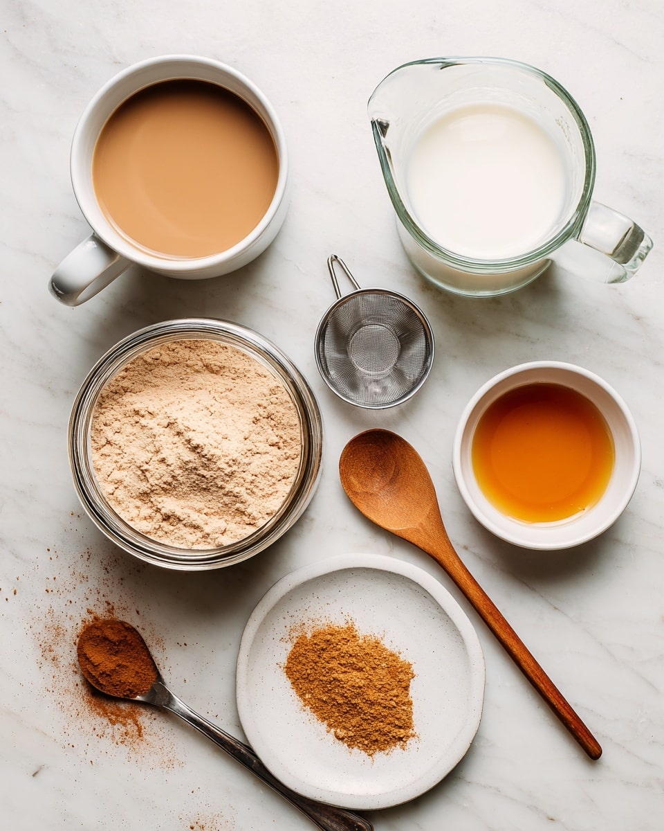 The image shows an overhead view of ingredients on a white marbled surface. There is a white mug filled with light brown coffee on the left side and a clear glass measuring cup filled with white milk on the top right. Below the mug is a small metal coffee filter parts, including a lid and a spout. In the center, there is a glass jar full of light brown powder. On the bottom right, there are two white plates; one with a small pile of orange-brown powder and the other with a light amber liquid. Two wooden spoons rest on the surface diagonally, one near the top and one at the bottom. There are small scattered piles of the orange-brown powder around the surface. photo taken with an iphone --ar 4:5 --v 7