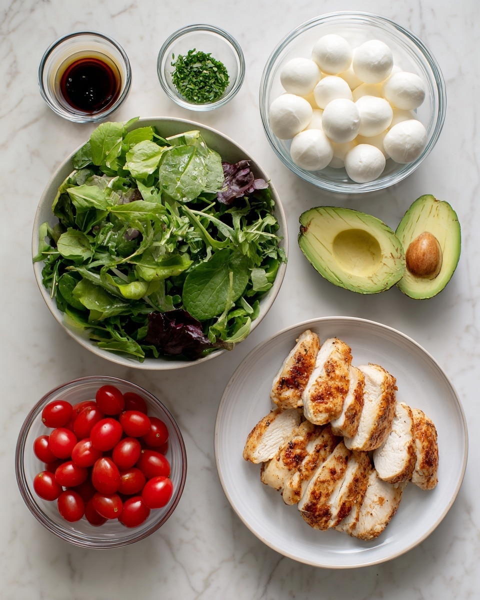 A white bowl filled with mixed green salad leaves sits on a white marbled surface, showing fresh, leafy textures in various shades of green. Next to it, on the right side, there is a white plate holding four pieces of golden-brown cooked chicken with visible grill marks and a slightly crispy texture. Above the chicken plate, a halved avocado rests with a smooth, green inner part and a large pit on one side. To the left of the chicken plate, there is a small glass bowl containing green herbs, finely chopped. Above the green herbs bowl, a larger glass bowl is filled with small white mozzarella balls, smooth and shiny. To the left of the mozzarella, a small transparent bowl contains a dark balsamic marinade with a glossy surface. Below the chicken plate, a small white bowl contains bright red cherry tomatoes, smooth and round. The whole scene is set on a clean white marbled surface. Photo taken with an iphone --ar 4:5 --v 7