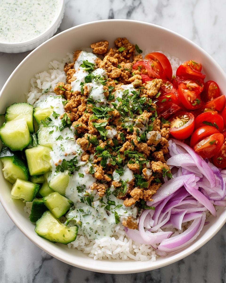 A white bowl holds a colorful layered dish starting with a base of fluffy white rice evenly spread at the bottom. On top of the rice, there is a layer of crumbled cooked meat in a light brown color, partially covered with white creamy sauce speckled with green herbs. Around the meat, three distinct sections of fresh vegetables are arranged neatly: bright red cherry tomatoes cut in halves, crisp pale-green cucumber chunks, and thin slices of purple-red onion. The whole dish is sprinkled with chopped fresh green herbs on top, creating a vibrant and fresh look. The bowl is placed on a white marbled surface with a small white bowl of extra sauce blurred in the background. Photo taken with an iphone --ar 4:5 --v 7