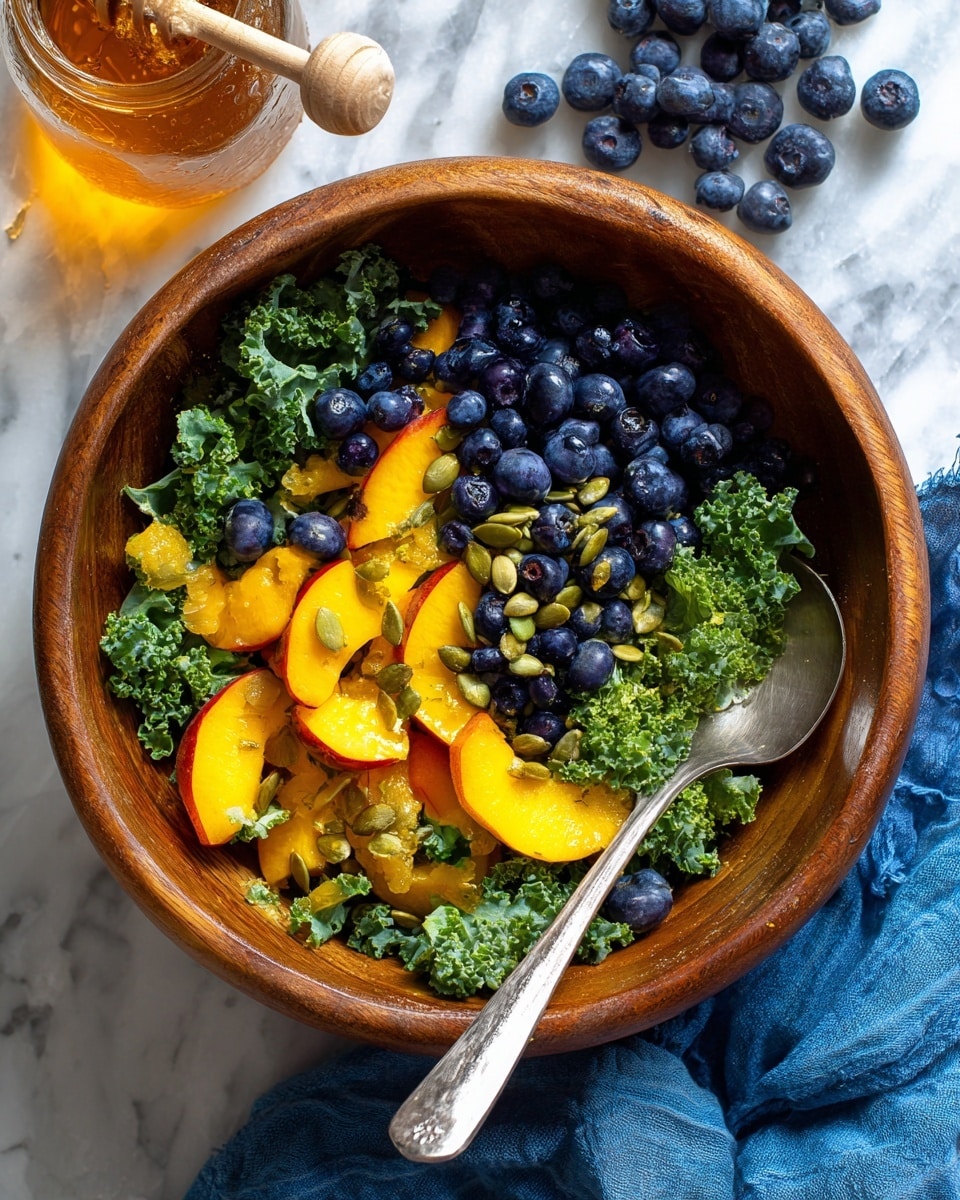A wooden bowl filled with a fresh salad, starting with a base layer of dark green kale leaves with a bumpy texture, topped with small round dark blue blueberries scattered evenly. Bright yellow-orange peach pieces with red edges are spread on top, adding a juicy and soft texture. Light green pumpkin seeds are sprinkled over the whole salad for a crunchy touch. A silver spoon is placed inside the bowl on the right side. The bowl is set on a white marbled surface with a glass container of honey visible in the upper left corner and some loose blueberries near the upper right corner, along with a blue cloth partially visible at the bottom. Photo taken with an iphone --ar 4:5 --v 7