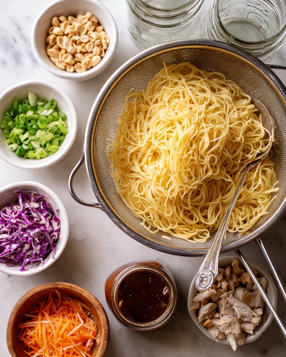 A clear metal colander holds a pile of plain yellow spaghetti noodles with a metal spoon inside, placed on a white marbled surface. Nearby, there are four clear empty glass jars with metal lids on the top right. Below the colander are five small white bowls and one wooden bowl arranged loosely; the white bowls contain chopped green onions, chopped roasted peanuts, and shredded mix of purple cabbage and orange carrots, while the wooden bowl holds small pieces of cooked white chicken meat. A small glass jar with thick dark brown sauce is also placed near the bowls. Photo taken with an iphone --ar 4:5 --v 7