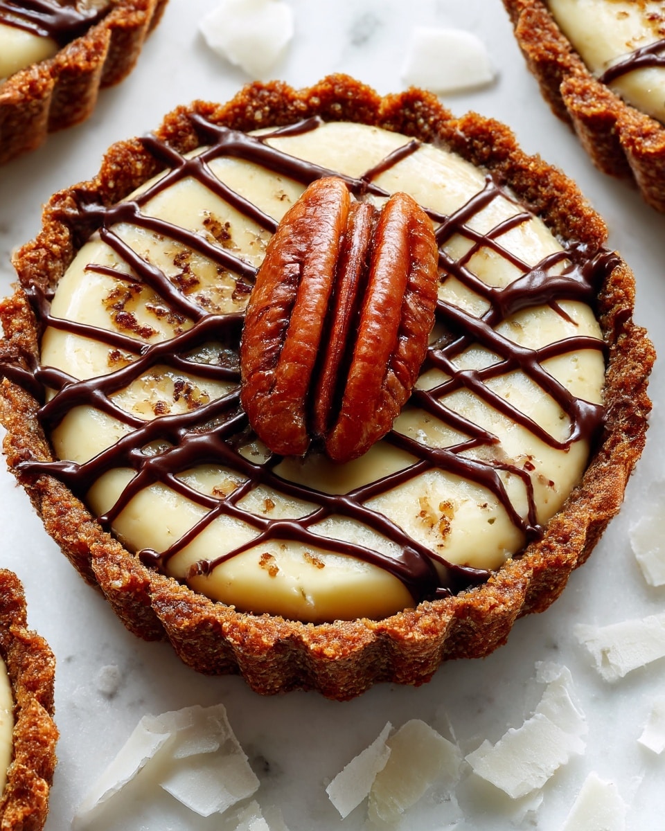 The image shows a close-up of a small tart with three main layers: a bottom brown crust that looks crunchy, a middle light beige filling with a moist, fibrous texture, and a top layer of dark brown chocolate drizzled in thin lines over a single whole pecan that sits in the center. The tart is on a white marbled surface with some white flaky pieces scattered around. photo taken with an iphone --ar 4:5 --v 7