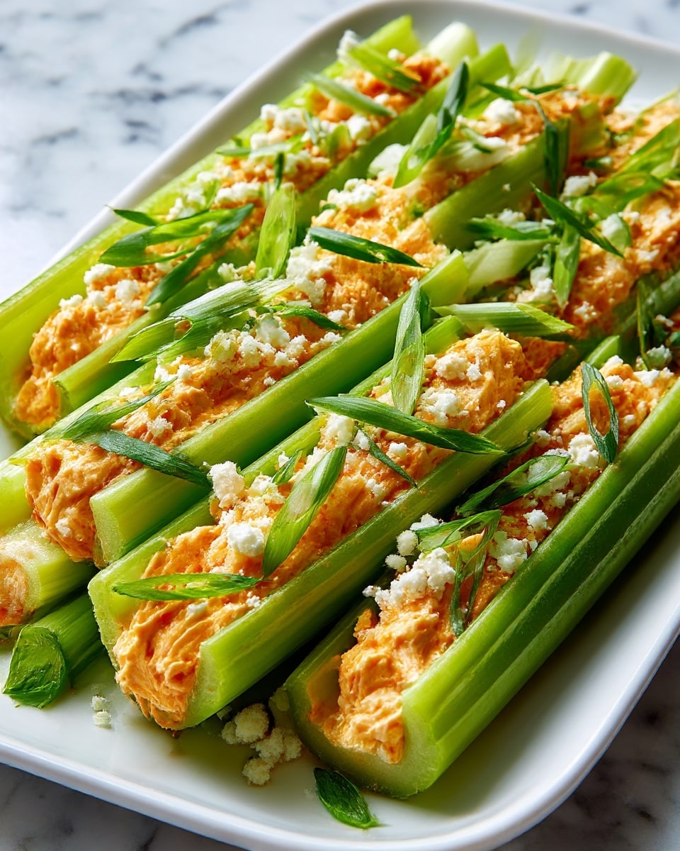 The image shows celery sticks filled with a creamy orange spread that looks soft and smooth. Each celery stick is bright green and hollowed out to hold the spread tightly inside. The filling has small white crumb bits sprinkled on top, along with thin slices of green onions as garnish. The celery sticks are arranged on a long white plate with a shiny surface that has slight reflections. The background and surface have a white marbled texture, giving a clean and fresh look. photo taken with an iphone --ar 4:5 --v 7