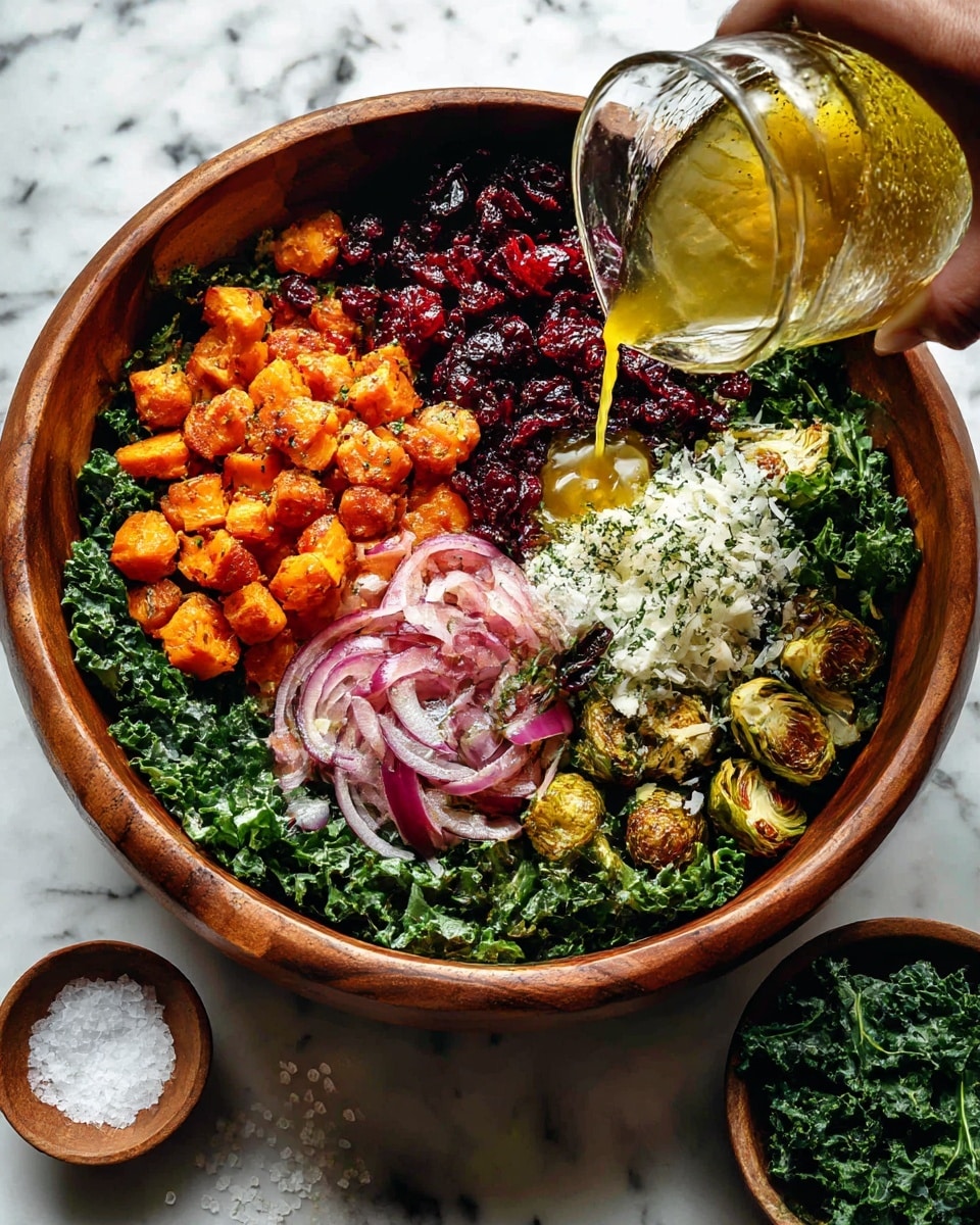 A large wooden bowl holds a layered salad with four main layers: the bottom layer is dark green kale leaves with a curly texture, layered above are bright orange roasted sweet potato cubes and golden-brown roasted Brussels sprouts cut in half, mixed with slices of cooked purple onion; on top of that is a layer of dark red dried cranberries, and the final layer is freshly grated white cheese piled on one side. A woman's hand is pouring golden yellow dressing from a clear glass container over the salad. The bowl is set on a white marbled surface with some salt and a small bowl of kale nearby photo taken with an iphone --ar 4:5 --v 7