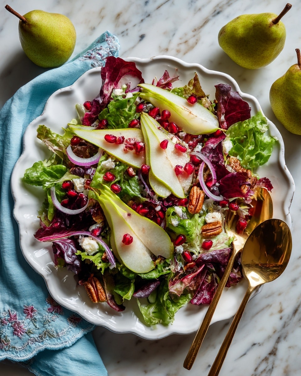 A white scalloped plate holds a fresh salad with a base layer of mixed green leaves including spinach and red-tinted lettuce, topped with thin slices of green pear arranged across the salad. Scattered on top are small pieces of white cheese, thin rings of light purple onion, bright red pomegranate seeds, and crunchy brown pecans. A gold spoon and fork rest on the right side of the plate. The plate sits on a white marbled surface with a light blue cloth napkin to the left and a couple of green pears and a yellow fruit to the right. A small white bowl with a light dressing is placed on the upper left. Photo taken with an iphone --ar 4:5 --v 7