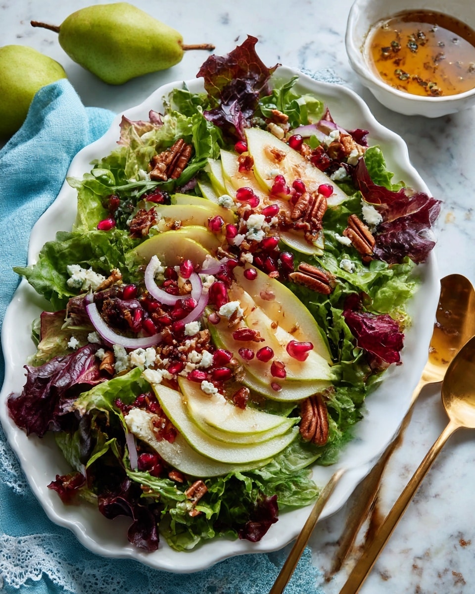 A white scalloped oval plate sits on a white marbled surface, filled with a colorful salad arranged in layers. The bottom layer is mixed leafy greens with deep green and reddish-purple leaves creating a fresh base. On top, thin slices of light green pear with white flesh are spread evenly across the greens. There are small scattered pieces of crumbled white cheese, thin rings of pale purple onion, and bright red pomegranate seeds adding vibrant color. Small brown pecans are sprinkled throughout the salad for texture. Two shiny gold spoons rest on the right side of the plate. In the background, a small white bowl with dressing and fresh green pears sit nearby. A light blue cloth with a lace edge is placed on the left side under the plate. Photo taken with an iphone --ar 4:5 --v 7