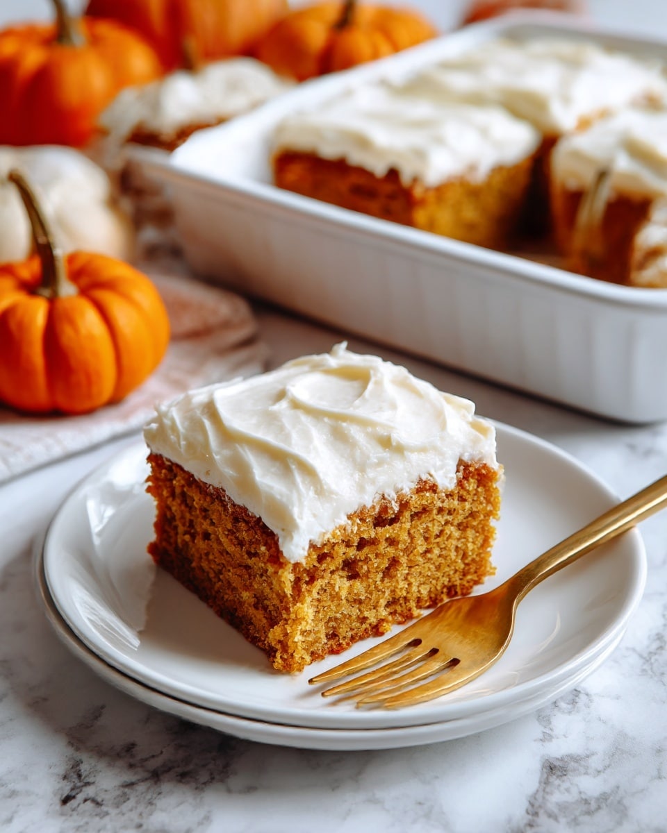 The image shows one rectangular slice of pumpkin cake with two layers: a thick, moist, light brown cake layer topped by a smooth, creamy white frosting layer. The slice sits on a white plate with a gold fork in front of it. In the background, there is a small orange pumpkin and a white baking dish filled with more cake. The surface and background have a white marbled texture. photo taken with an iphone --ar 4:5 --v 7